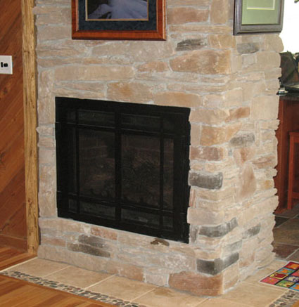 Black fireplace insert set in a stone surround free of stains after restoration and cleaning service