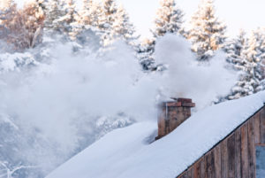 chimney with smoke on snowy roof
