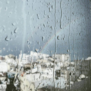 rain and rainbow outside a window pane