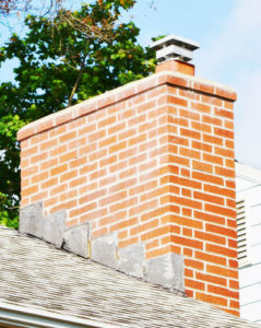 faded brick chimney with cap and crown