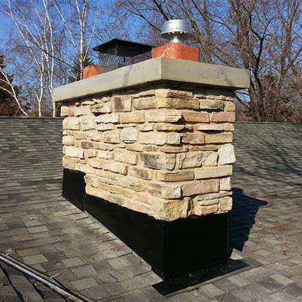 Custom stone chimney masonry with new crown and refreshed flashing