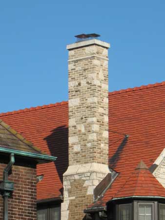 Completed masonry repairs on custom stone chimney with new stainless chimney caps